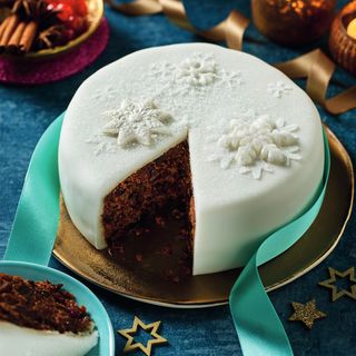 Morrisons The Best Iced Christmas Cake on a gold plate with blue ribbon