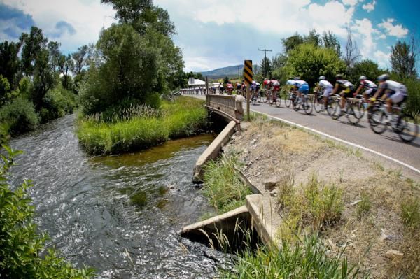 The bunch passes over a creek along the route.