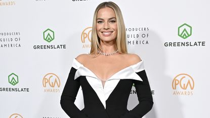 Margot Robbie wearing a black-and-white mini dress with a black top handle back and a diamond choker