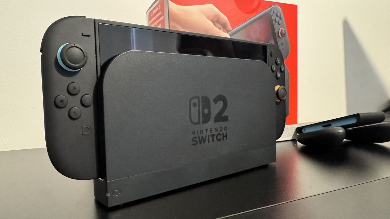 A picture of Nintendo Switch 2 dock with the console inside, and the Switch 2 box behind it