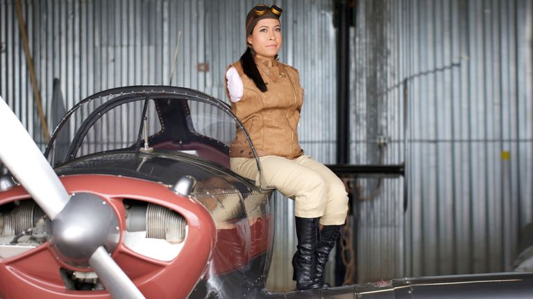 Jessica Cox sitting on the edge of a small single engine propeller plane.