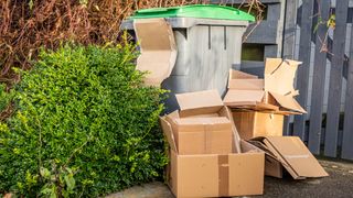 Cardboard boxes outside by trash bin