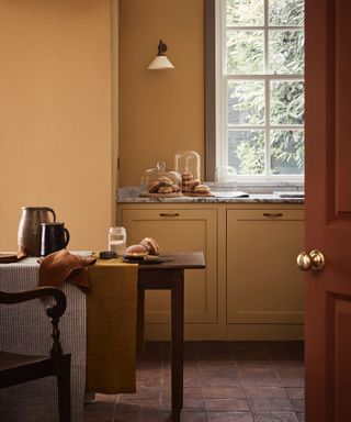 yellow kitchen with dining table, cabinets and walls matching, marble countertops,