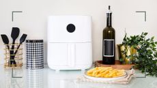 white kitchen with a white air fryer with a plat of cooked chips to ask are air fryers toxic