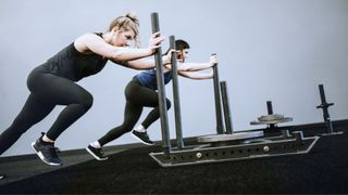 Women pushing sleds at the gym