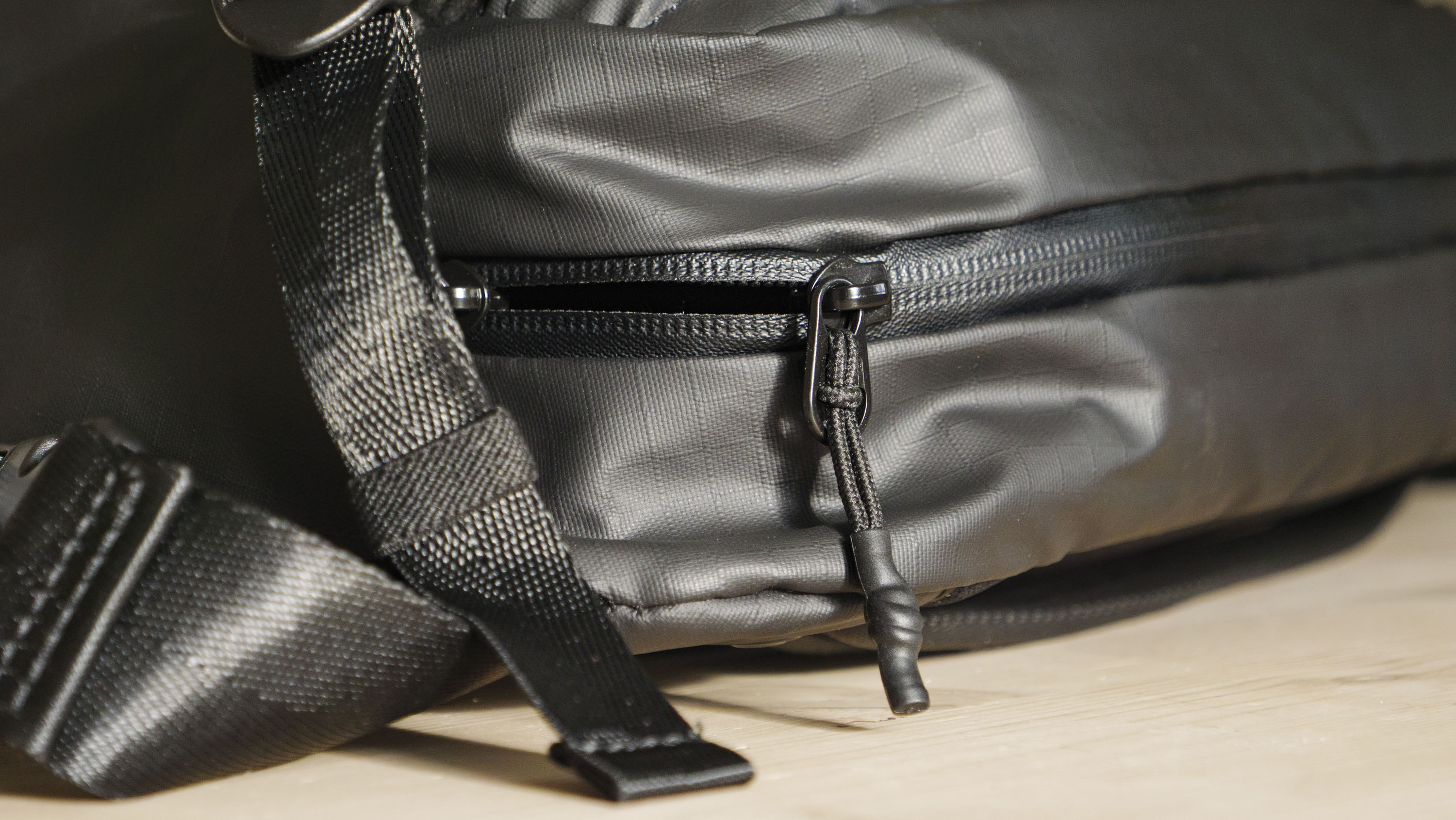 The Ulanzi Camera Sling Bag on a wooden table, zip closeup