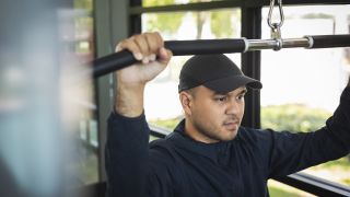 Man performs lat pull-down