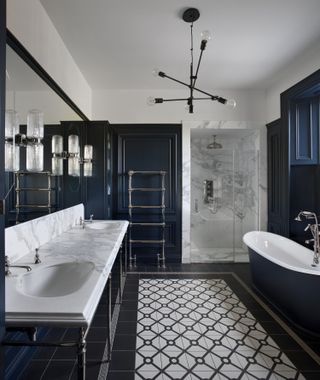 A bathroom with wall sconces and a ceiling light