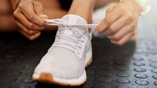 close up of woman tying shoe