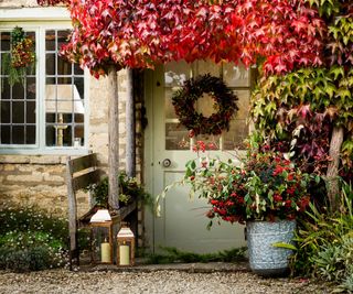 Autumn leaves over a door, with a festive wreath