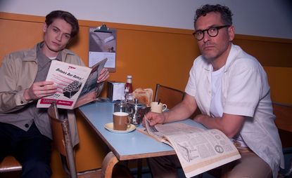 Two people at a dining table with reading material