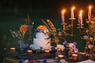 candles and flowers on table in dark at wedding in garden