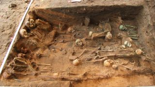 One of the excavated plague pits showing bodies in seated and lying positions.