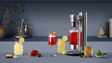 Breville InFizz on a grey countertop with various sparkling drinks around it