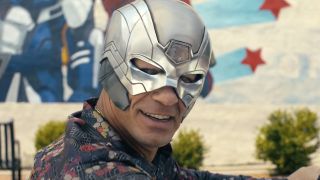 John Cena as Peacemaker wearing his Peacemaker helmet and smiling