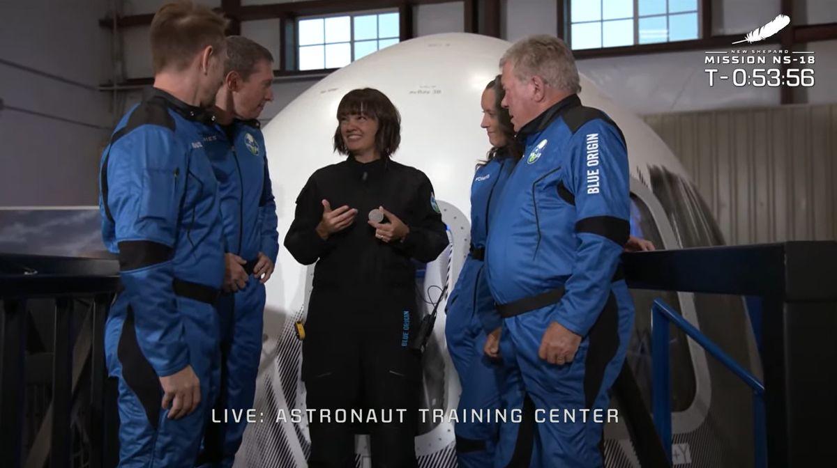 Blue Origin's Crew Member Seven Sarah Knights presents William Shatner and his three crewmates their commemorative challenge coins to signify the completion of their training for the NS-18 launch..