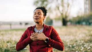 A woman meditating outdoors