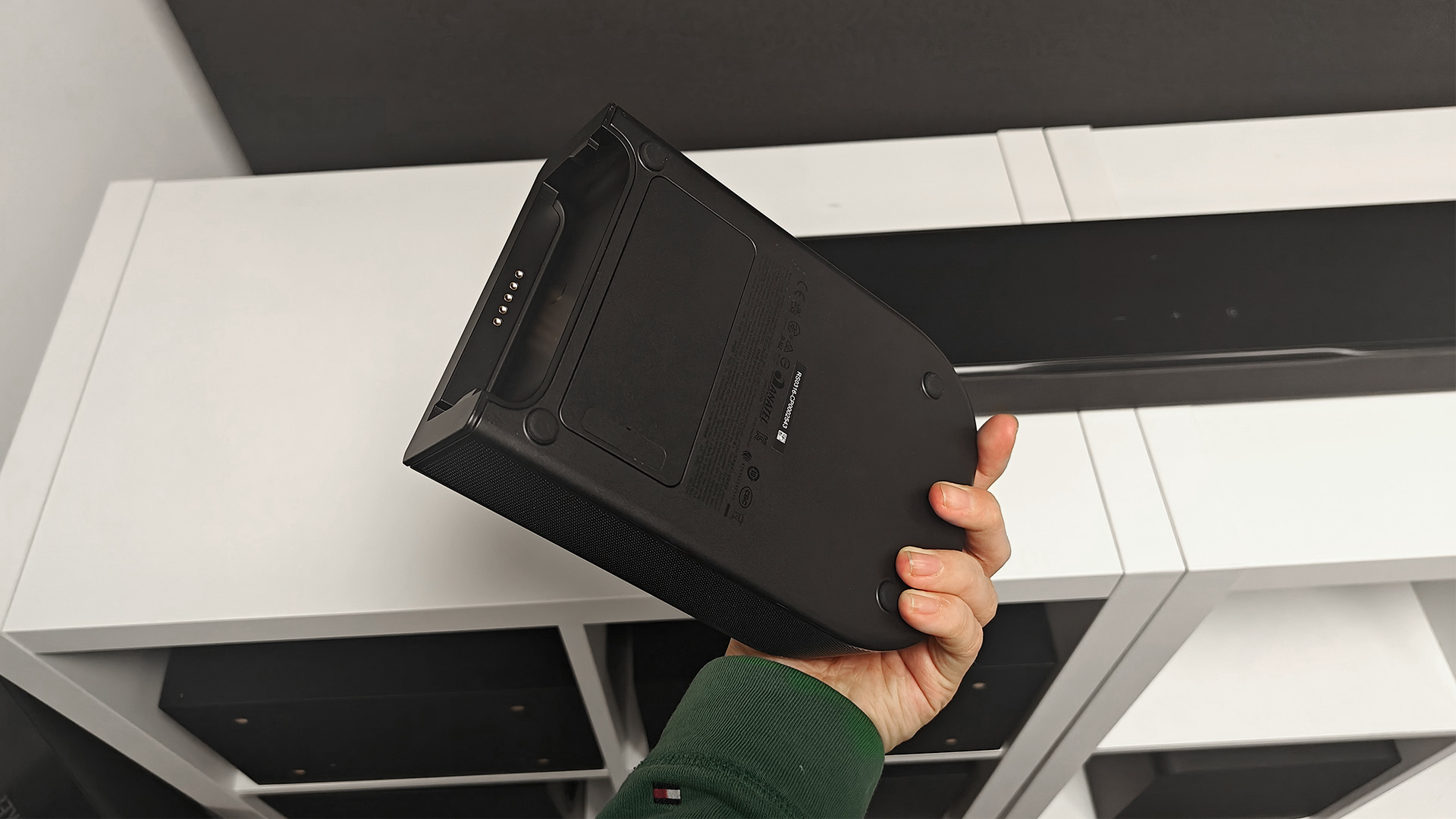 JBL Bar 1000MK2 soundbar system with surround speaker held in hand above soundbar