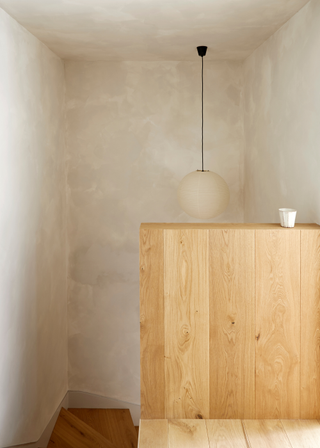 A simple wooden staircase with a rice paper pendant lantern