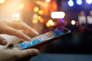 Man using mobile payments in front of a night background