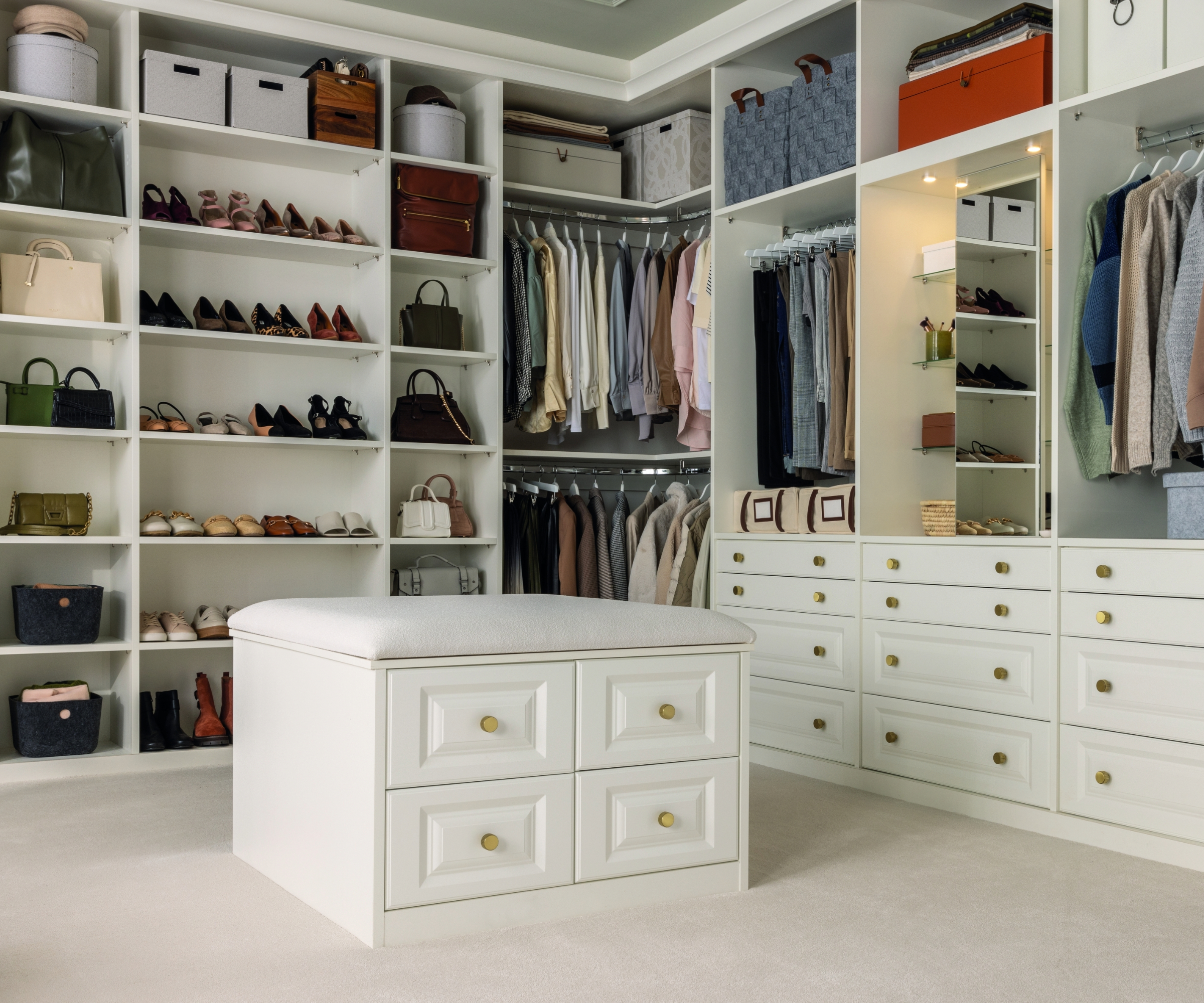 Dressing room featuring an open wardrobe alongside the back and side wall, with an island in the middle