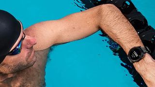 Man swimming wearing Garmin Forerunner 745 watch
