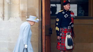 Queen Elizabeth II walks past The Queen's Piper, Pipe Major Richard Grisdale of The Royal Regiment of Scotland