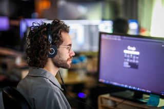 Lux Aeterna AI tools; a man looks at a computer monitor