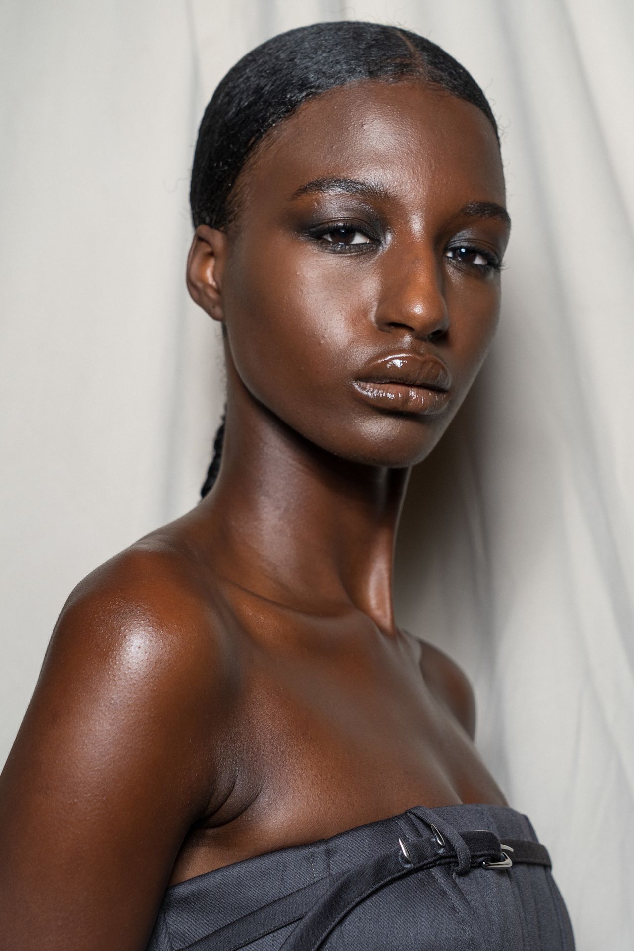 Bold eyeliner&mdash;and no mascara at Sandy Liang on a model with slicked back hair and a strapless top.