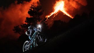 Kilian Bron riding as a volcano erupts behind