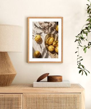 A lemon art print next to a wooden console