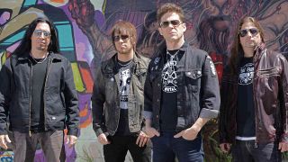 Jason Newsted and his band in front of a graffiti covered wall