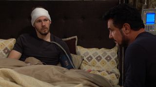 Liam (Scott Clifton) sits in bed with Bill (Don Diamont) by his side in The Bold and the Beautiful