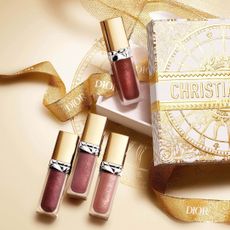 Dior Beauty selection of lip glosses on gold Christian Dior wrapping paper