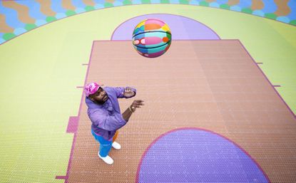 Yinka Ilori playing at the basketball court he designed for London's Canary Wharf Estate, May 2021