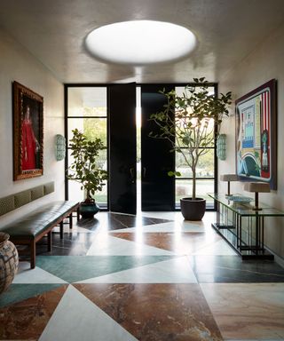 Large entryway with patterned flooring, gray walls, double doors and vintage art