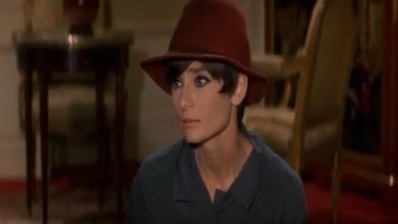 Audrey Hepburn in a red hat in How To Steal A Million