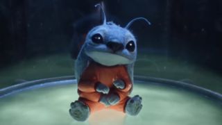 Stitch sits in his containment capsule with a curious look on his face in the live-action Lilo & Stitch remake.