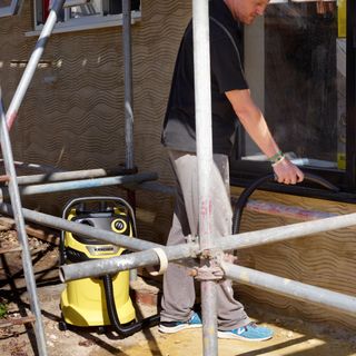 A builder using a Kärcher WD 5 to blow dust off a window sill