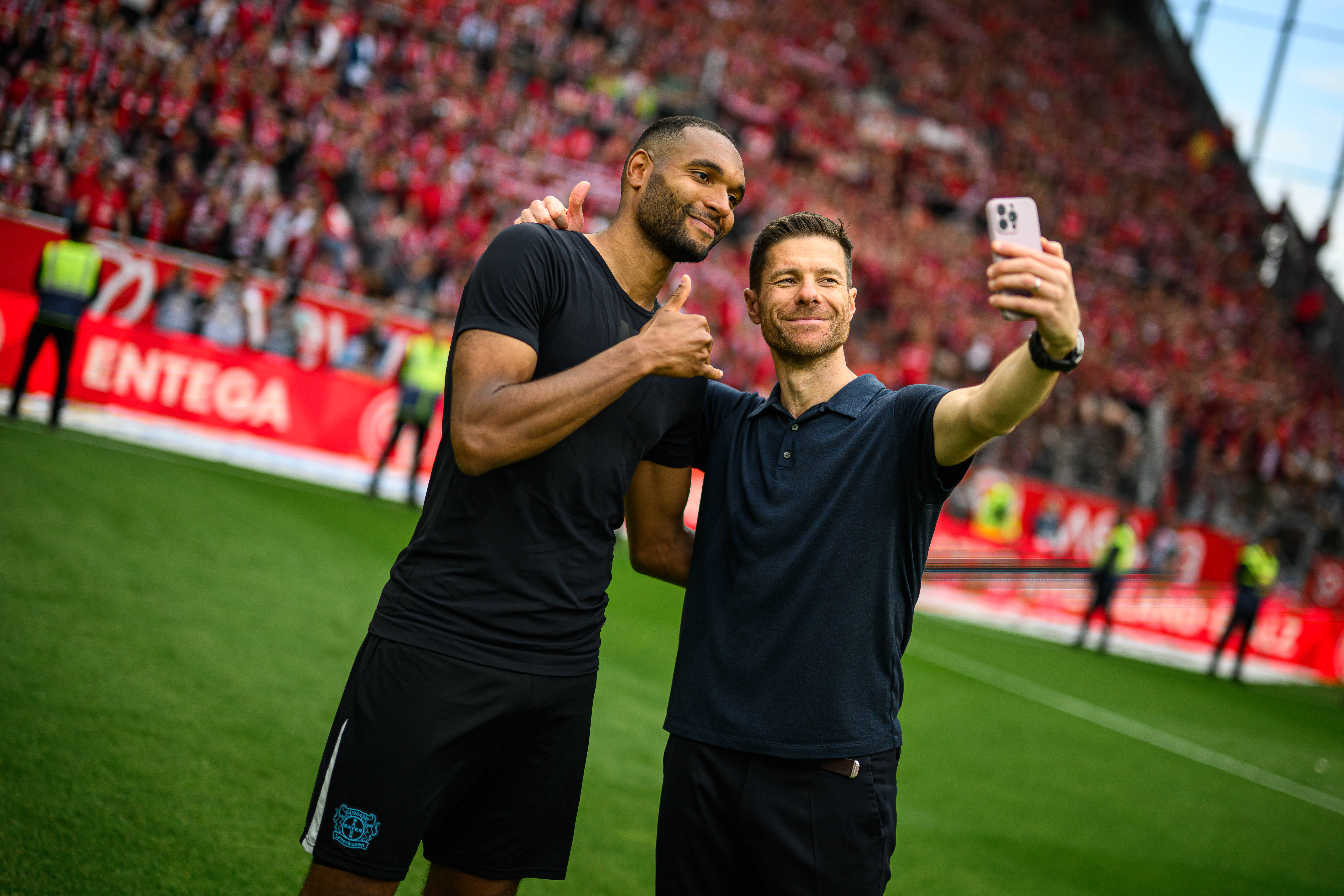 Bayer Leverkusen coach Xabi Alonso and defender Jonathan Tah pose for a selfie after a league game against Mainz in May 2025, the last for both men at the Bundesliga club.