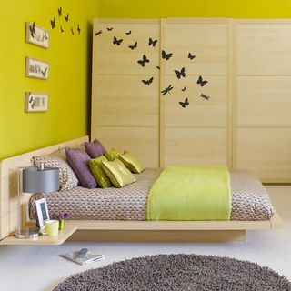 bedroom with lime yellow wall and butterfly door stickers