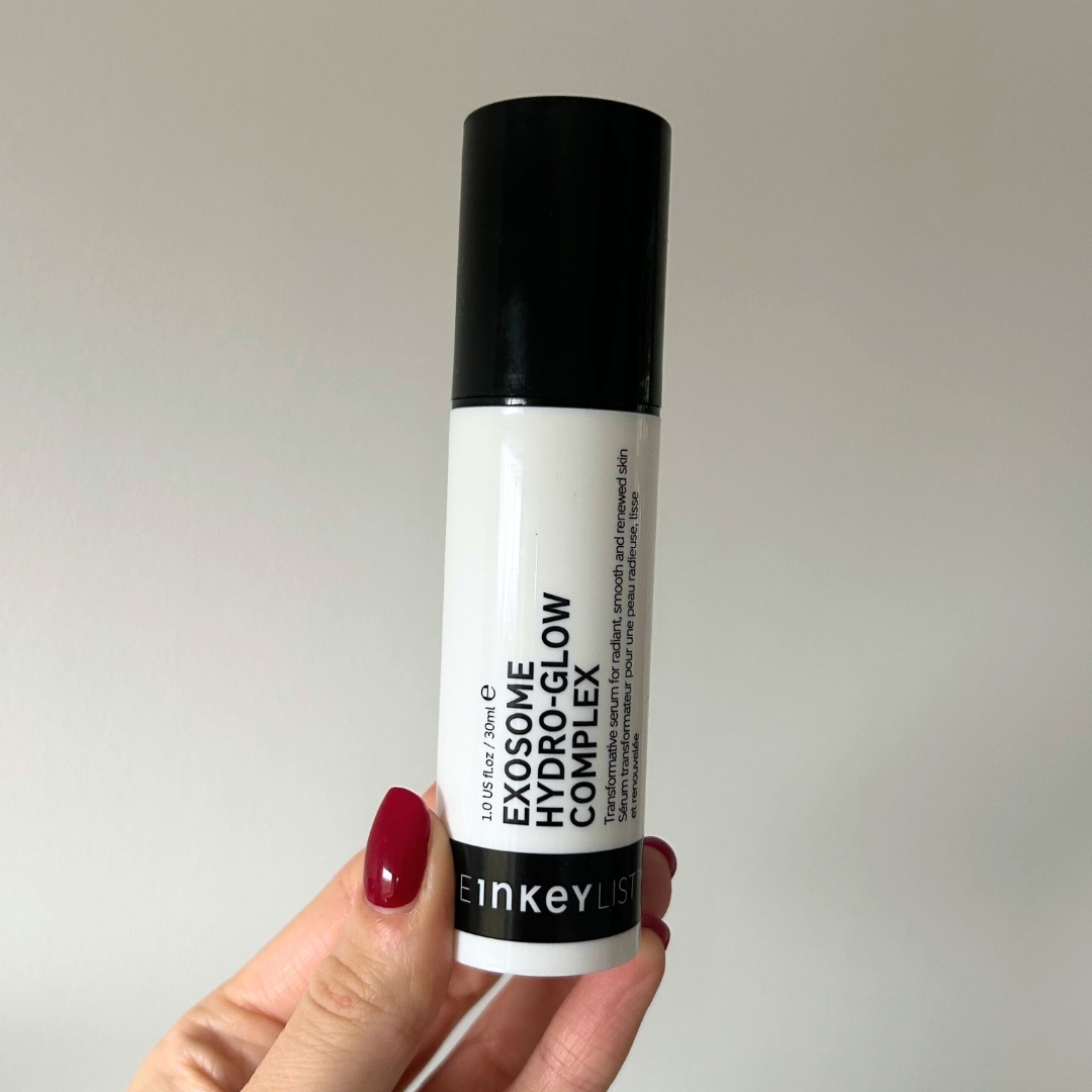 Hand holding white and black bottle of The Inkey List Exosome Hydro-Glow Complex
