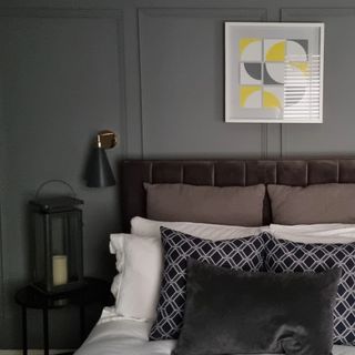A grey themed bedroom with grey walls, grey bedding and a grey crushed velvet headboard