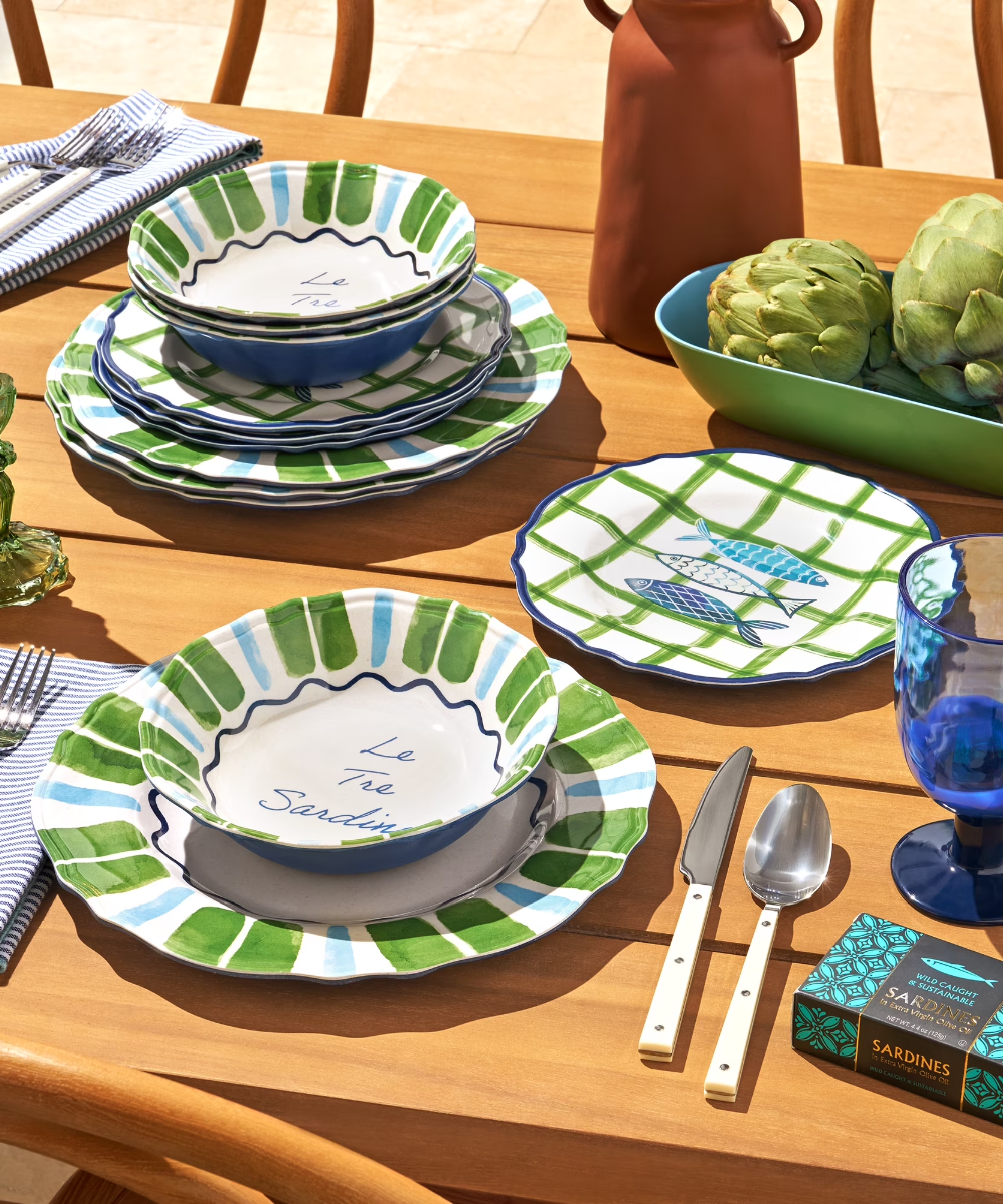 a green, white, and blue dinnerware set with sardine motifs on it