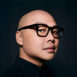 Daniel Martin poses for a headshot while wearing a pair of glasses.