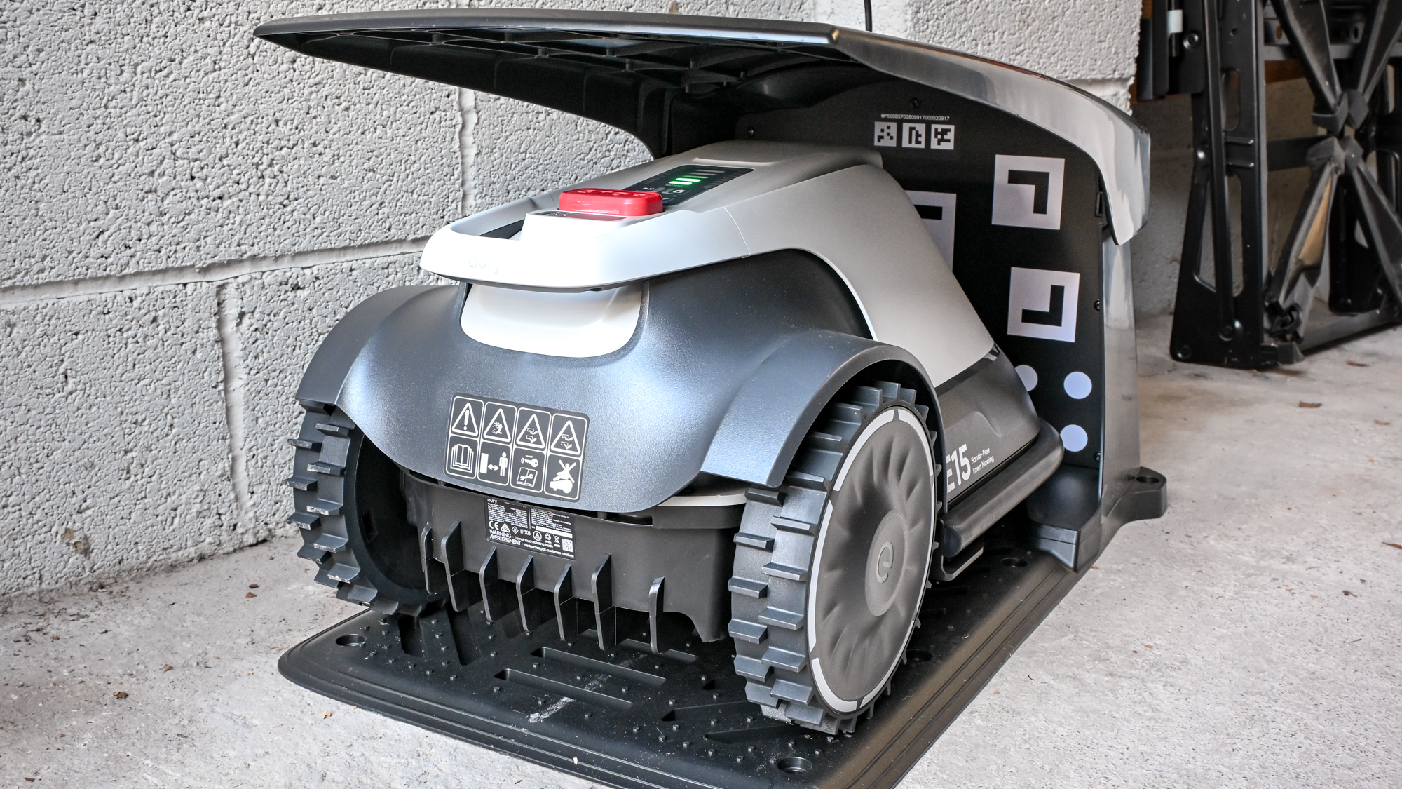 The Eufy E15 robot lawnmower in its base garage