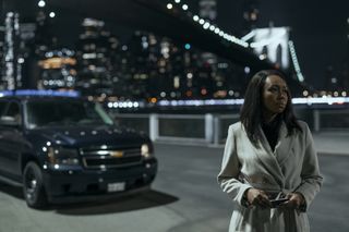 Catherine stands by the bridge at night in The Night Agent season 2