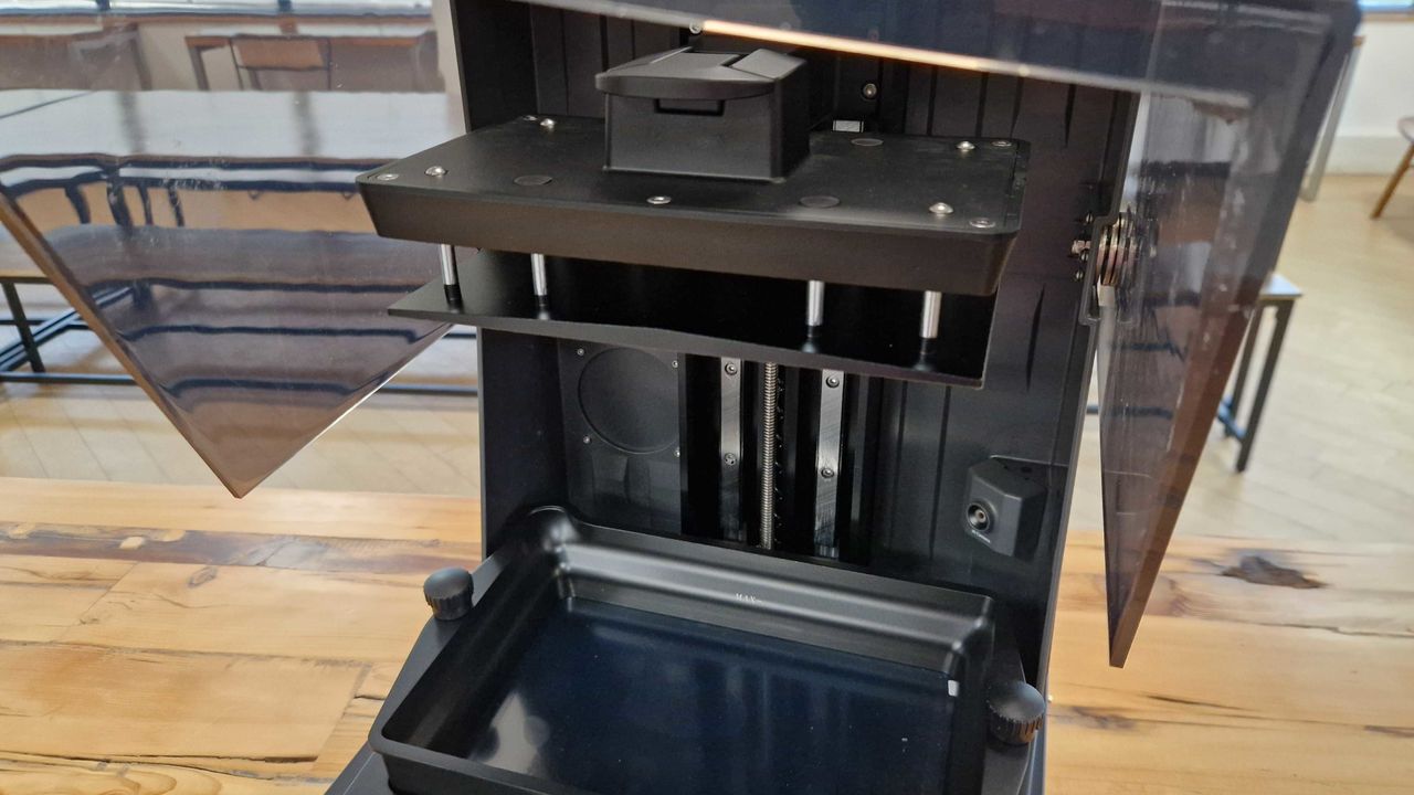 Elegoo Saturn UItra 4 Pro with its lid open, on a wooden table
