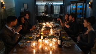 Black Bag - the cast sits around a candelit table in conversation