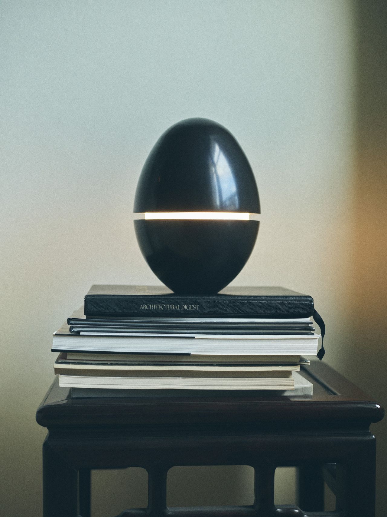 A series of products from Zara Home designed by NYC's Colin King, including red lacquered nesting tables, a red vessel, an egg-shaped lamp, and a basked woven in brass.